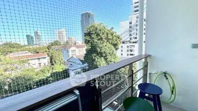 Charming balcony with city view and safety netting, perfect for relaxation in urban setting.