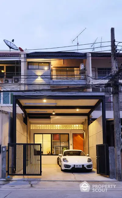 Modern townhouse with sleek garage and luxury car parked, showcasing contemporary urban living.