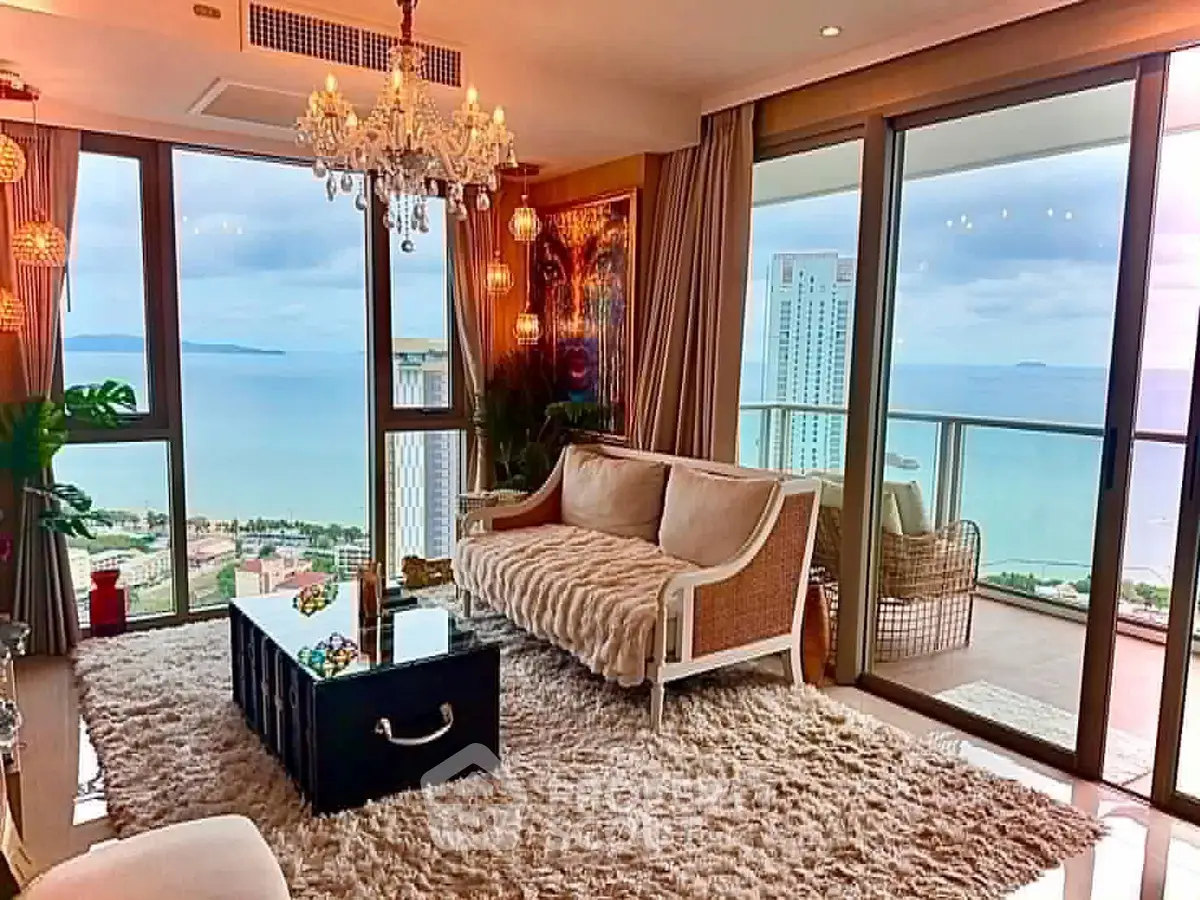 Luxurious living room with ocean view, elegant decor, and spacious balcony in high-rise apartment.