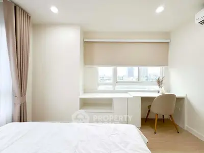Bright and modern bedroom with study area and large window view.