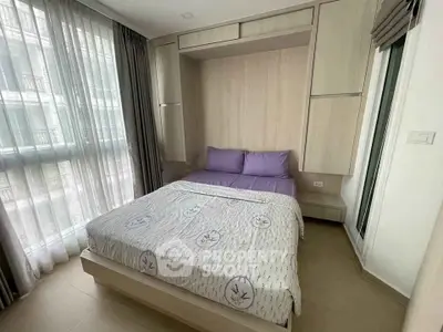 Cozy bedroom with modern design and ample natural light from large windows.