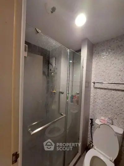 Modern bathroom with glass shower enclosure and tiled walls