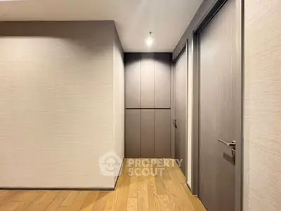 Modern hallway with wooden flooring and sleek doors in a contemporary apartment.