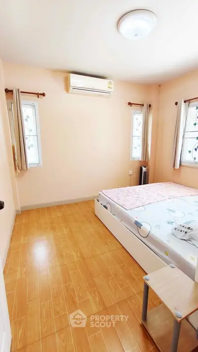 Cozy bedroom with wooden flooring and natural light