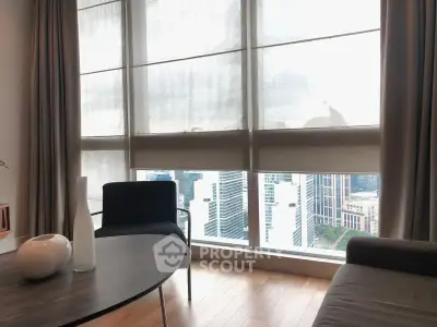 Modern living room with large windows offering stunning city view, featuring elegant furniture and decor.