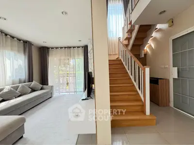 Modern living room with staircase and large windows in a stylish home