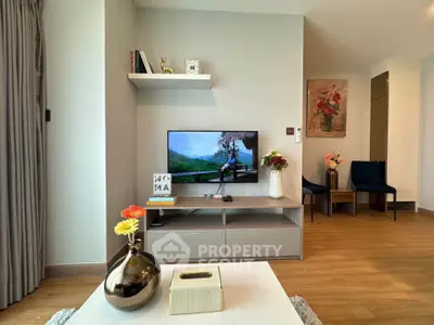 Modern living room with stylish decor and wall-mounted TV, featuring elegant wooden flooring.