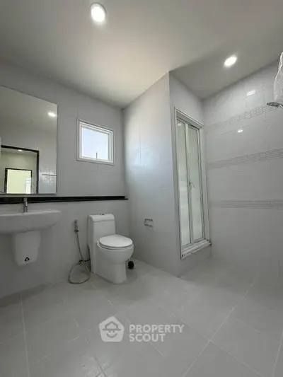 Modern bathroom with sleek design, featuring a shower and contemporary fixtures.