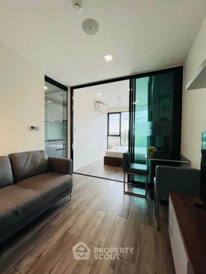 Modern living room with sleek design and open layout, featuring a cozy sofa and dining area with natural light.