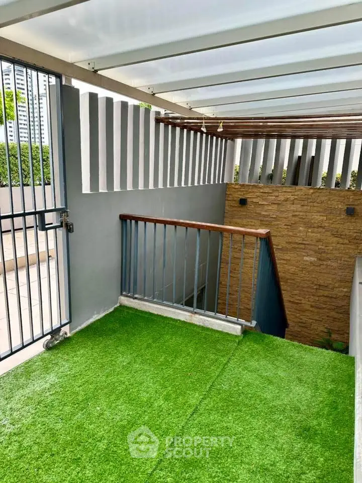 Modern rooftop terrace with artificial grass and stylish railing