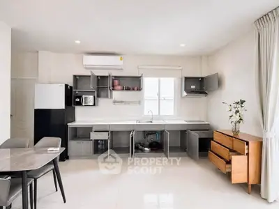 Modern kitchen with open cabinets, sleek appliances, and elegant dining area in a bright, spacious interior.