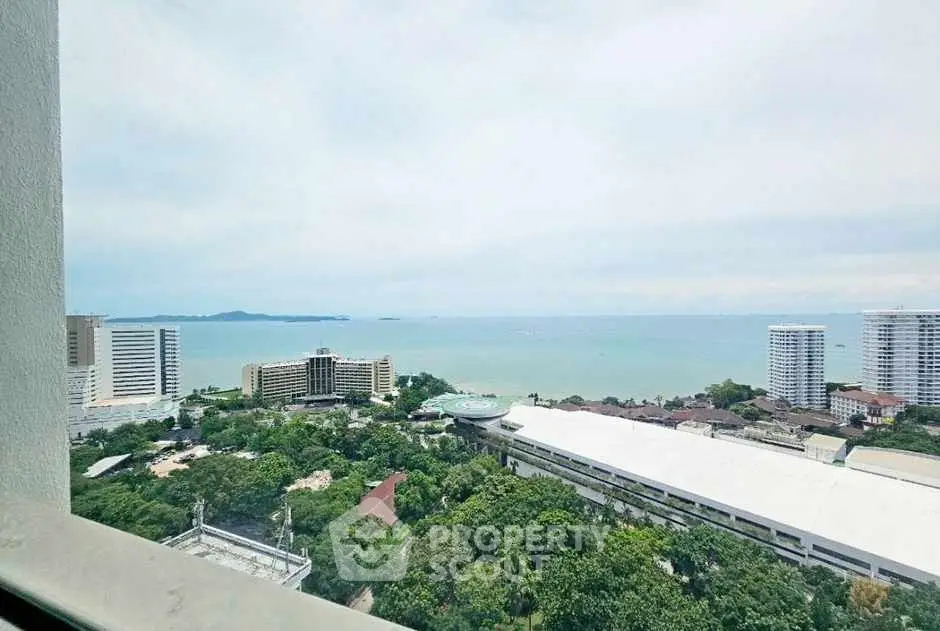 Stunning ocean view from high-rise apartment window overlooking cityscape and sea.