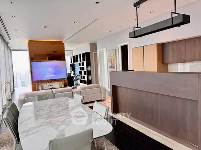 Luxurious open-plan living room with modern kitchen and stunning city view.