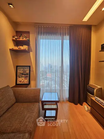 Cozy living room with modern decor and city view through large window.
