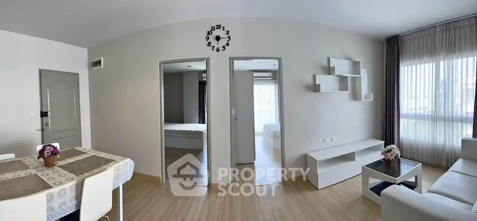 Modern living room with stylish decor and open layout, featuring a dining area and natural light.
