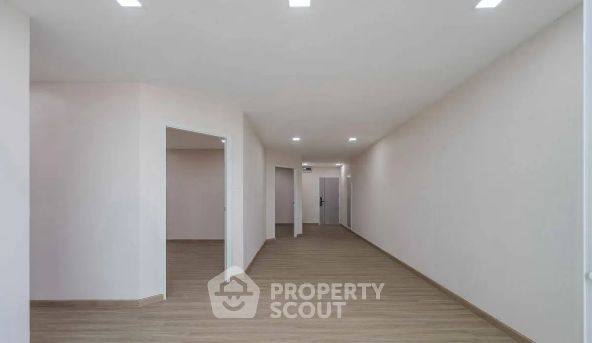 Spacious modern hallway with wooden flooring and recessed lighting