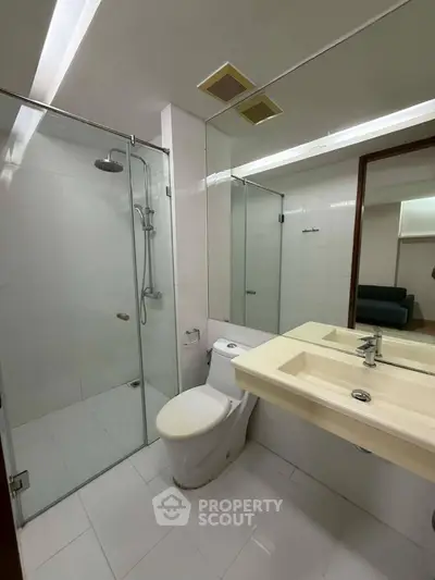 Modern bathroom with glass shower and sleek fixtures in a contemporary apartment.
