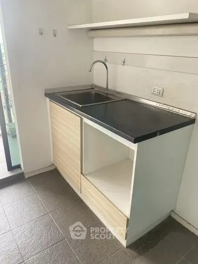 Compact kitchen area with sleek countertop and sink, ideal for modern apartments.