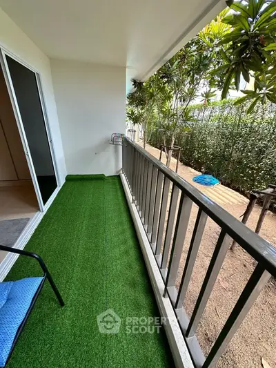 Charming balcony with artificial grass and garden view, perfect for relaxation and outdoor enjoyment.