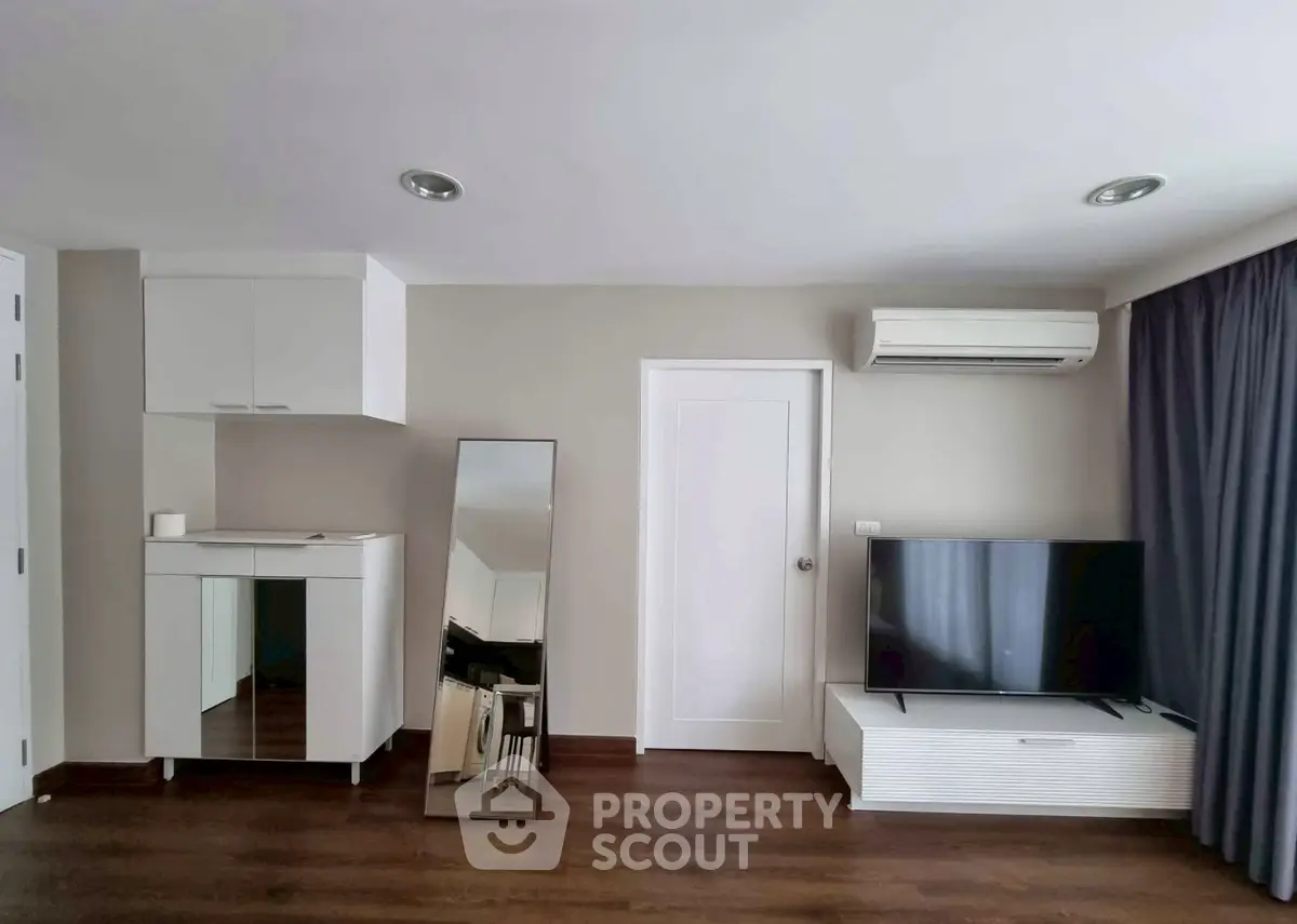 Modern living room with sleek TV setup and stylish mirror accent