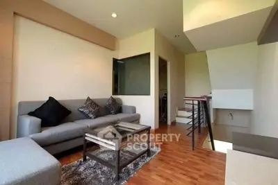Modern living room with stylish furniture and wooden flooring in a cozy apartment.