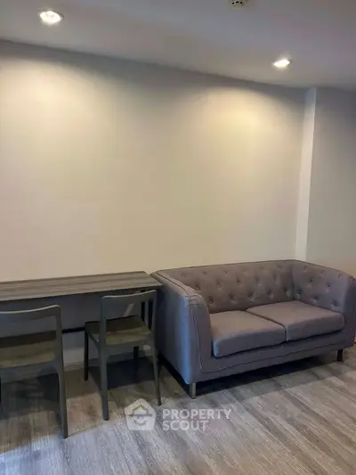 Modern living room with stylish gray sofa and sleek dining table, perfect for contemporary urban living.