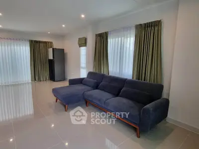 Spacious living room with modern blue sofa and large windows