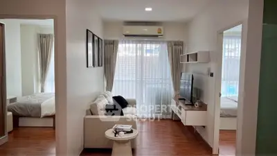 Modern living room with cozy seating and natural light in a stylish apartment.