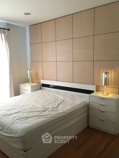 Modern bedroom with stylish panel wall and natural light