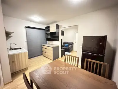 Modern open-plan kitchen and dining area with sleek wooden finishes and contemporary furniture.