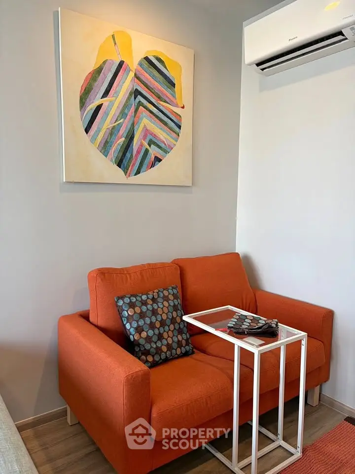 Cozy living room with vibrant orange sofa and modern wall art, perfect for relaxation and style.