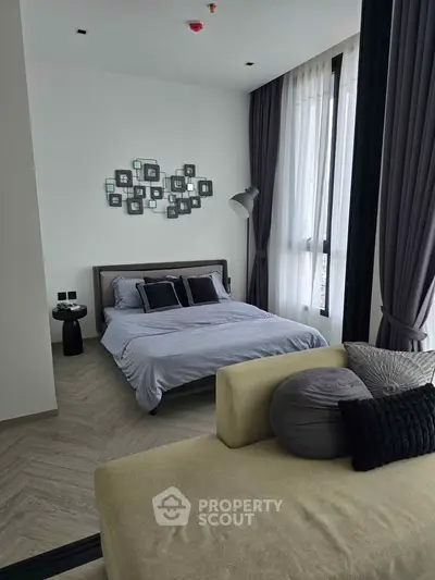 Modern bedroom with stylish decor and large windows for natural light.