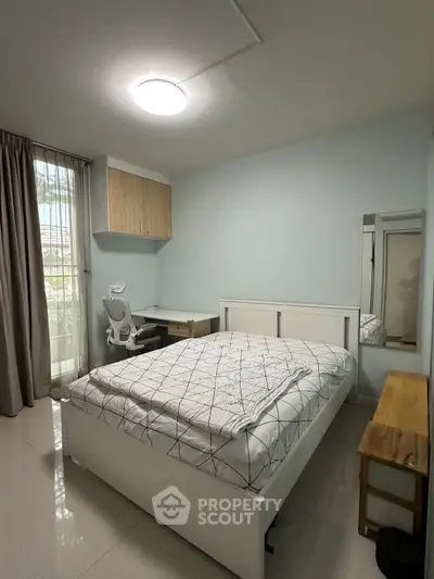 Modern bedroom with natural light, featuring a cozy bed, study desk, and stylish decor.