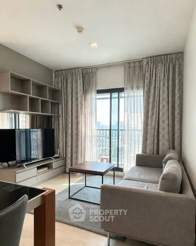 Modern living room with stylish furniture and city view balcony in a high-rise apartment.