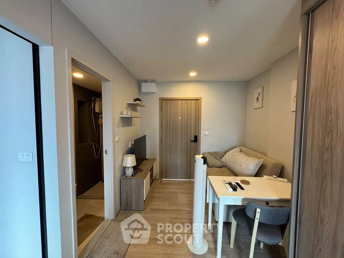 Cozy living room with modern decor and dining area in a compact apartment.