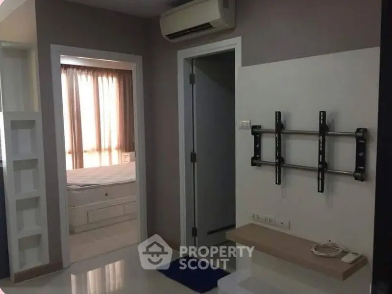 Modern apartment interior with wall-mounted TV bracket and air conditioning.