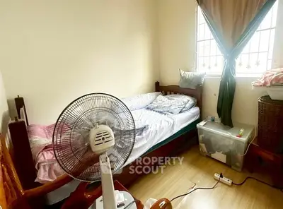 Cozy bedroom with natural light, featuring a single bed and fan, ideal for comfortable living.