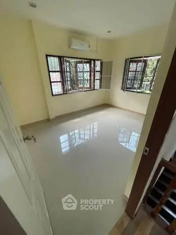 Spacious empty room with large windows and glossy floor, perfect for customization.