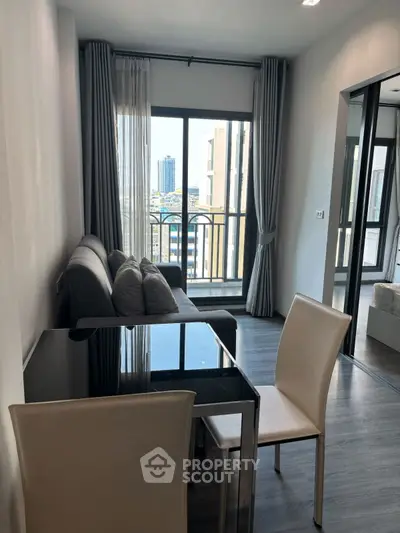 Modern living room with balcony view, sleek furniture, and natural light in urban apartment.