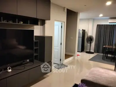 Modern living room with sleek entertainment center and dining area, featuring contemporary furniture and neutral tones.