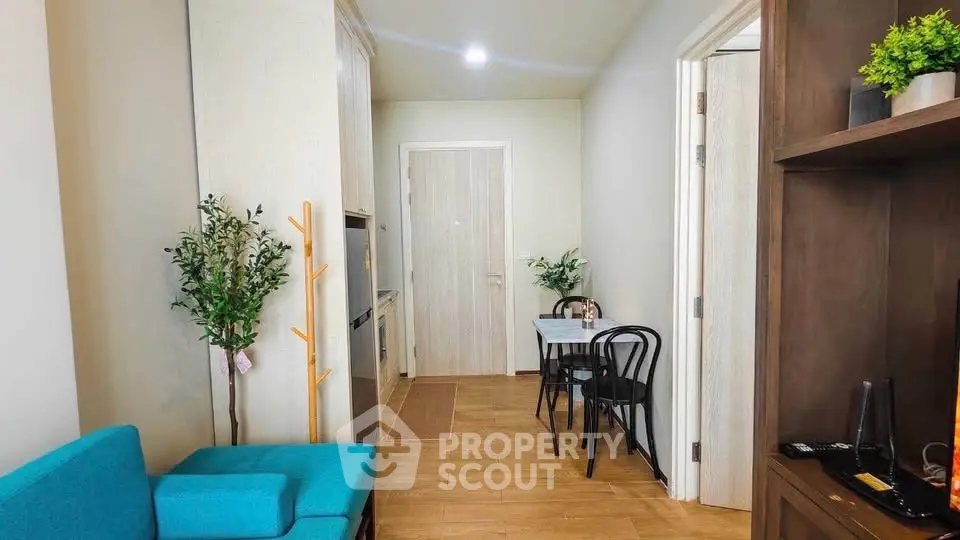 Charming apartment interior with cozy seating and dining area, featuring modern decor and wooden flooring.