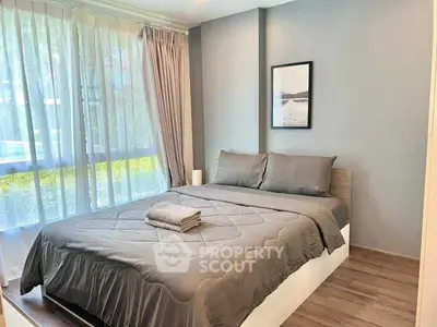 Cozy bedroom with large window and modern decor in a stylish apartment.