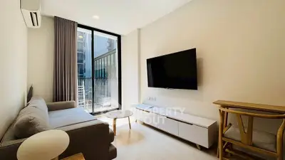 Modern living room with sleek furniture and large window offering natural light.