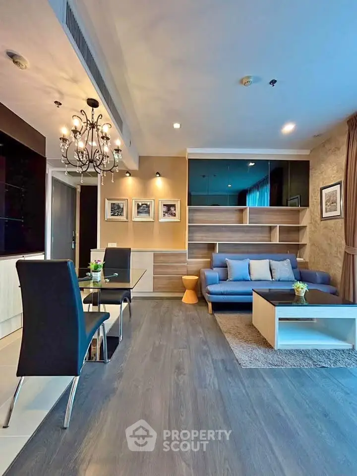 Modern living room with elegant chandelier and stylish furniture in a contemporary apartment.