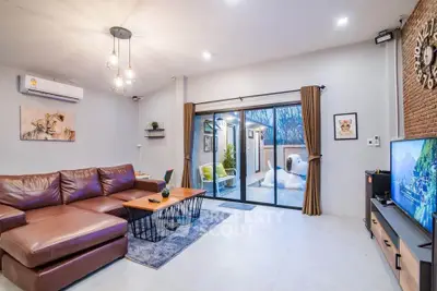 Modern living room with leather sofa and sliding glass doors to balcony