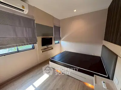 Modern bedroom with sleek design, featuring built-in storage and natural light.