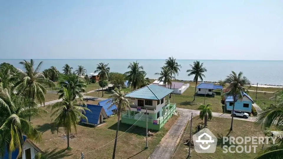 Scenic beachfront property with palm trees and ocean view, perfect for a tropical getaway.