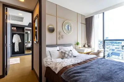 Luxurious bedroom with city view, elegant decor, and ample natural light in modern apartment.