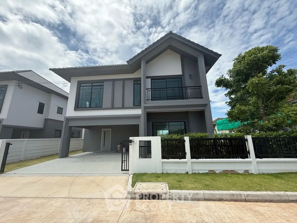 Modern two-story house with spacious driveway and lush greenery