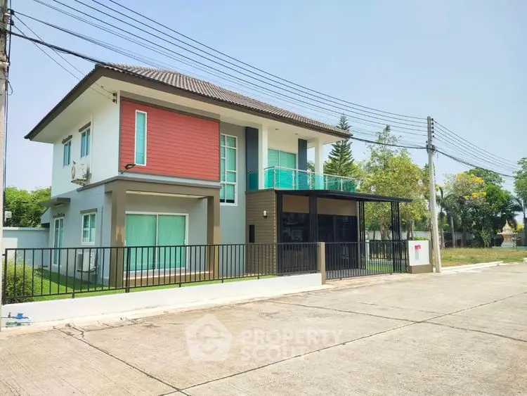 Modern two-story house with balcony and spacious driveway in a serene neighborhood.